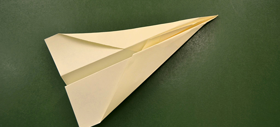 Avión de papel sobre una pizarra