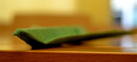 Avión de papel verde sobre una mesa